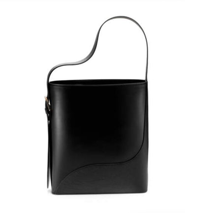 The black Benesh handbag in italian leather from Studio DRÈA that was featured in the Harper's Bazaar France Magazine as one of the trends of the season in a white background